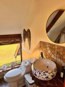 a bathroom with a sink and a toilet and a mirror at Terevaka Lodge Rapa Nui in Hanga Roa