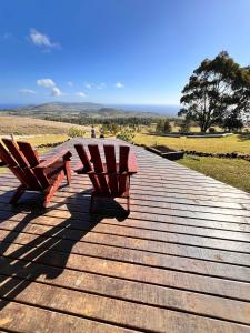 two benches sitting on top of a wooden boardwalk at Terevaka Lodge Rapa Nui in Hanga Roa +4 photos