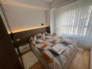 a small bedroom with a bed and a window at UrbanNest Aerodrom in Skopje