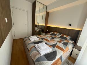 a bedroom with a large bed with a mirror at UrbanNest Aerodrom in Skopje