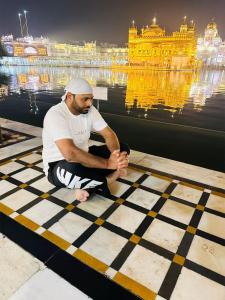 ジュネーヴにあるJassの黄金寺院の前の床に座っている男性