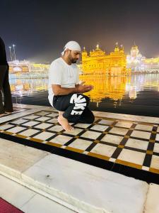 ジュネーヴにあるJassの黄金寺院の前の床に座っている男性