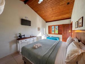 プライア・ド・ローザにあるPousada Lagoa do Rosaのベッドとテレビのある寝室