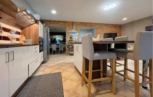 eine Küche mit weißen Schränken und eine Bar mit Hockern in der Unterkunft Maison Piscine in Cabannes + 22 Fotos