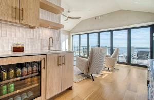 a kitchen with a counter and chairs and a view of the ocean at GP58: 58 Grand Pavilion in Isle of Palms