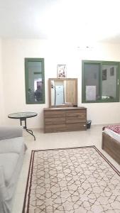 a living room with a couch and a table and mirrors at Dragon Golden Apartment 2 in Dubai