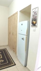 a white refrigerator in a room with a door at Dragon Golden Apartment 2 in Dubai