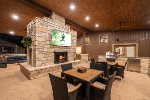 eine Lobby mit Kamin, Tischen und Stühlen in der Unterkunft Terracotta Bliss Wimberley Retreat Sleeps 28 in Woodcreek