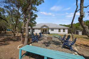 Eine Gruppe blauer Bänke vor einem Haus in der Unterkunft Terracotta Bliss Wimberley Retreat Sleeps 28 in Woodcreek