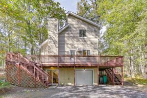 a house with a large deck and a garage at 6 Mi to Bushkill Falls Secluded Home with Game Room in Saw Creek