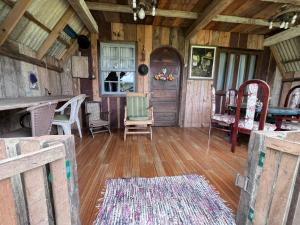 a room with chairs and a door in a cabin at Chalé do lago rústico in Campo Alegre