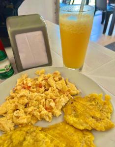 a plate of scrambled eggs and a glass of orange juice at Casa sol palomino in Palomino