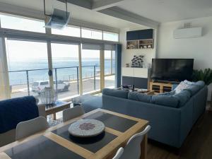 a living room with a couch and a table and a television at crystal blue apartment in Port Vincent