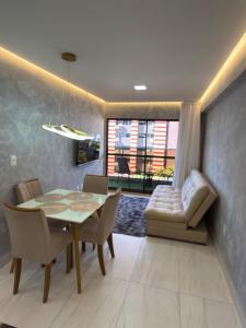 a dining room with a table and chairs and a couch at Comfort and elegance in the heart of Cabo Branco in João Pessoa