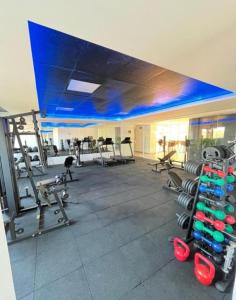 a gym with several treadmills and a blue ceiling at West Fit Padrão 05 in Mossoró