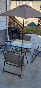 a table and chairs with an umbrella on a patio at The Nook Suite in Hackensack