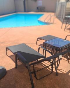 two picnic tables in front of a swimming pool at BK's Fountain Court Motel in Napier
