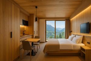 a bedroom with a bed and a desk and a window at Neues Alpenstudio in Schladming in Rohrmoos