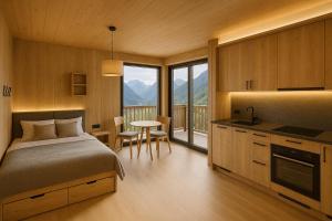a bedroom with a bed and a kitchen with a table at Neues Alpenstudio in Schladming in Rohrmoos