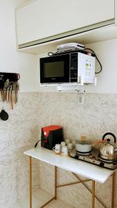 a microwave on top of a counter in a kitchen at Apartamento com ótima localização! in Belém