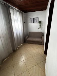 a living room with a couch in a room with windows at Casa Floripes in Cayru