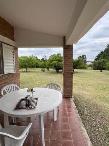 ein weißer Tisch und Stühle auf einer Terrasse mit Blick auf ein Feld in der Unterkunft Casa en Potrero de Garay in Potrero de Garay + 35 Fotos
