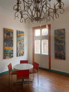 a dining room with a table and chairs and a chandelier at La Mancha Art Hostel in Valparaíso