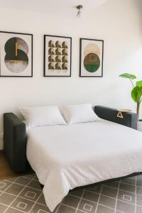 a bedroom with a bed with four pictures on the wall at Luxury Loft en el corazón de Providencia - piscina y parking gratis in Santiago