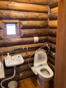 a bathroom with a toilet and a sink in a log cabin at Ekinoyado Hirafu in Kutchan +66 photos