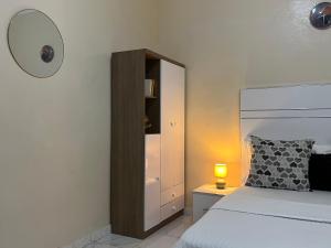 a bedroom with a bed and a mirror and a lamp at Chambre climatisée , wifi , serviettes, café ou thé offert in Dakar