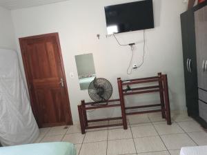 アウテル・ド・ションにあるAlter do Chão- Casa 01のファンとテレビが壁に備わる客室です。