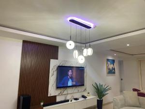 ein Wohnzimmer mit einem TV und einem Sofa in der Unterkunft Madrid at Invent Apartments in Lekki