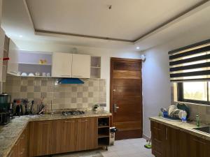 eine Küche mit Holzschränken und einer Holztür in der Unterkunft Madrid at Invent Apartments in Lekki