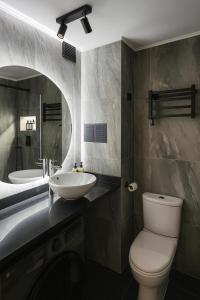 a bathroom with a sink and a toilet and a mirror at Luxury Loft en el corazón de Providencia - piscina y parking gratis in Santiago