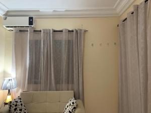 a living room with curtains and a couch at Chambre climatisée , wifi , serviettes, café ou thé offert in Dakar +22 photos