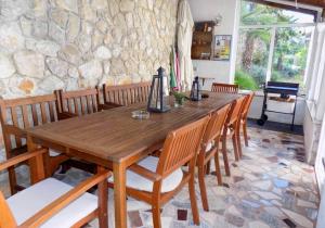 einen Holztisch mit Stühlen und eine Steinmauer in der Unterkunft Studio Moscenice 7689a in Mošćenička Draga + 19 Fotos