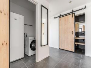 eine Waschküche mit einer Waschmaschine und einem Spiegel in der Unterkunft Luxury farmhouse in Baarle-nassau in Schaluinen