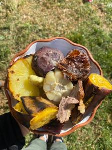 une personne tenant un bol de viande et de légumes dans l'établissement Cabañas lago piuray, à Chincheros