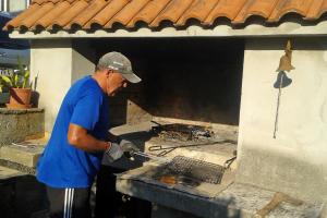 a man in blue shirt preparing food on a stove at Apartments by the sea Cove Pokrivenik, Hvar - 8673 in Zastražišće