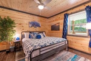 a bedroom with a bed in a log cabin at Wooded Circle - Barrel sauna, hot tub, fire pit in Hico