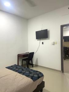 een slaapkamer met een bed, een bureau en een televisie bij Apartaestudio Suite 201 in Montería