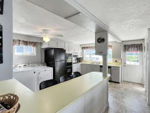 een keuken met witte kasten en een zwarte koelkast bij Sweet Dreams in Wells