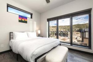 una camera da letto con un letto grande e una grande finestra di Solstice Abode a Hideaway Park