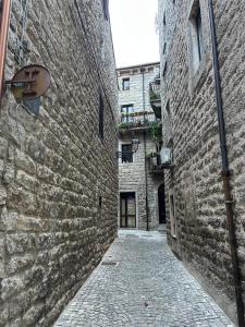 Une allée dans un ancien bâtiment en pierre dans l'établissement Villa Pietra Sardinia - Luxury 165 m2 Historic Stone House with Fireplace and Rooftop, à Tempio Pausania