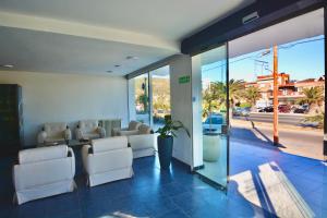 a waiting area with white chairs and a waiting room at Hotel Montecarlo PSH in Villa Carlos Paz