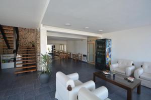 a living room with white furniture and a dining room at Hotel Montecarlo PSH in Villa Carlos Paz