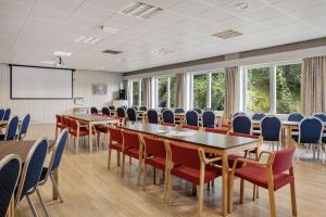 a conference room with tables and chairs and a screen at Hotell Heia-Elverum-Flisa-Våler i Solør in Våler i Solør