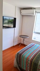 a room with a bed and a table and a tv at El Derby 511 Apart 1 Dorm con Aire Acondicionado in Lima