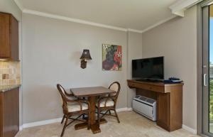 une salle à manger avec une table et une télévision dans l'établissement Luana Waikiki, à Honolulu