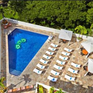 - une vue de tête sur une piscine avec des chaises longues et une piscine dans l'établissement Luana Waikiki, à Honolulu